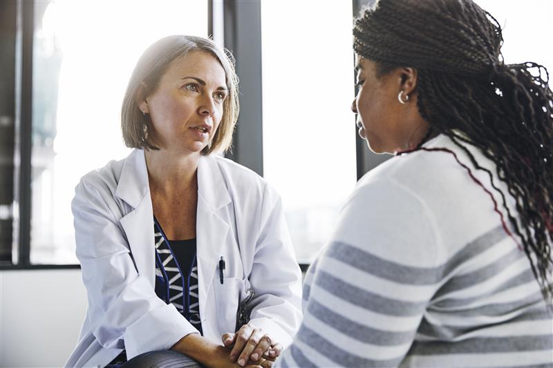 medical counselor sits with patient