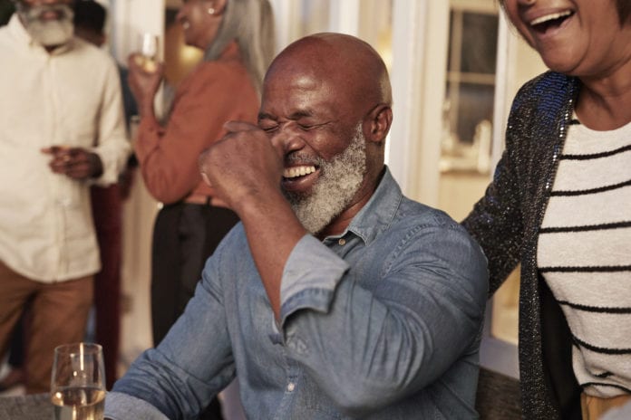 Cheerful man and woman enjoying birthday party at home
