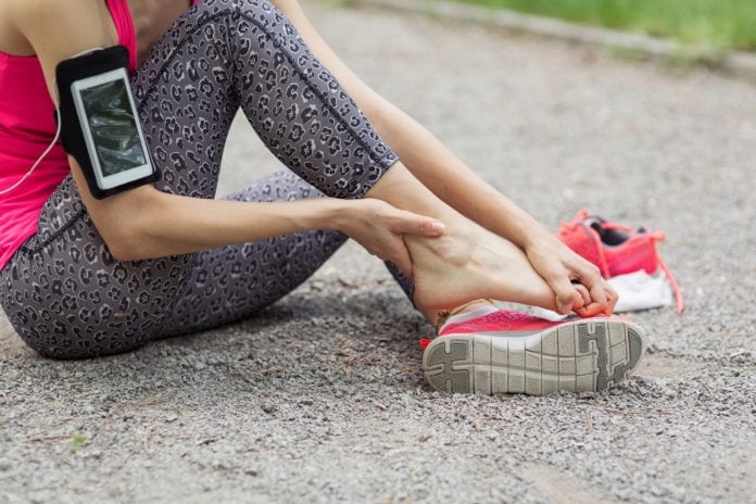 Girl in pain holding her foot 