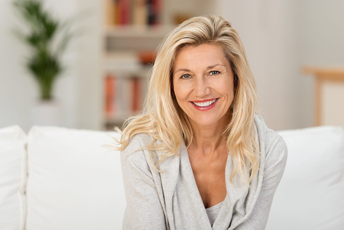 Woman smiling while sitting on a couch