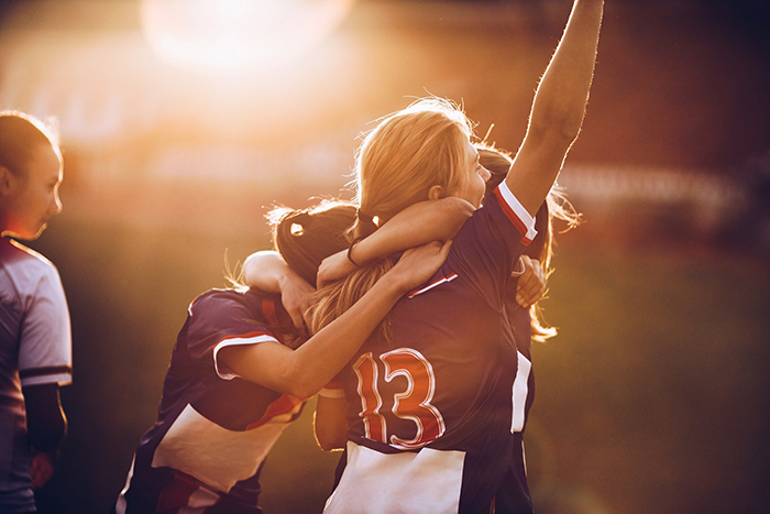 female athletes celebrating on the field