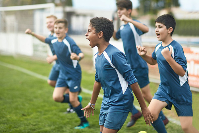 A group of kids playing soccer outdoors