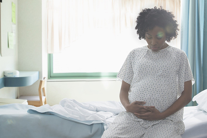Pregnant Woman sitting in a bed 