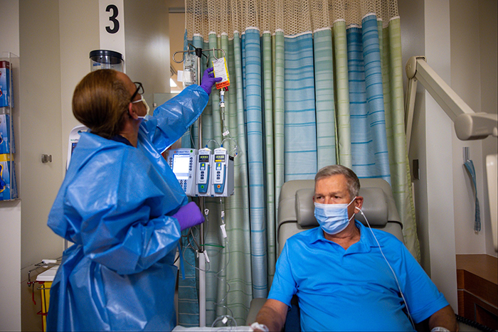 man in hospital room hooked up to an iv 