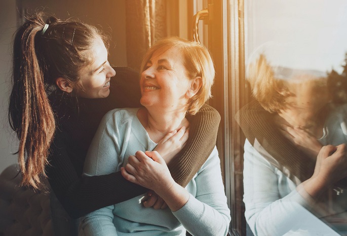patient hugs and smiles at caregiver