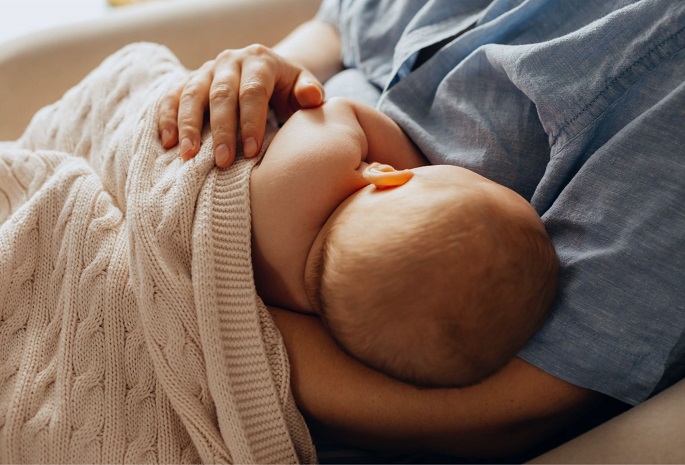 back view of infant being breastfed by mother