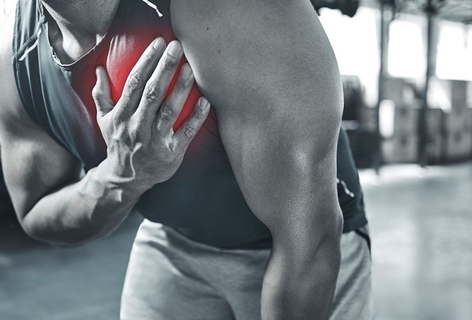 athletic man holds chest