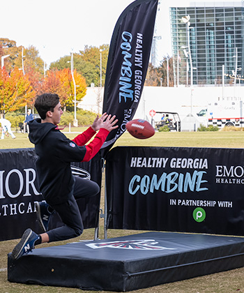 A person catches a football while jumping 