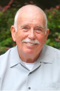 Clive, patient of a cancer clinical trial, smiles at camera