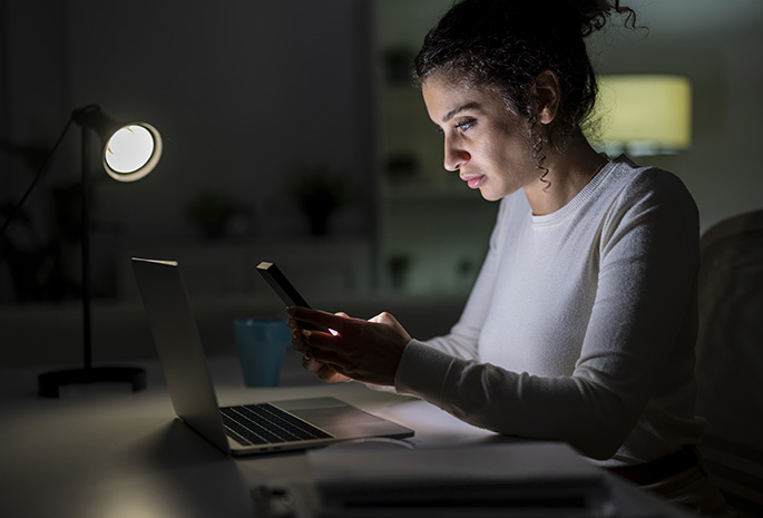 Woman searching information on her phone at home