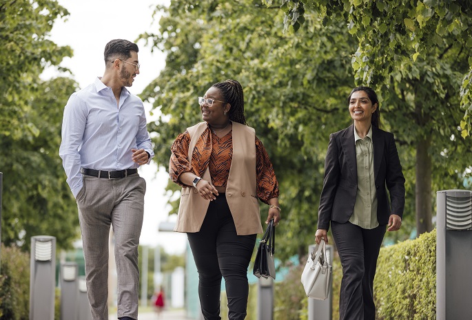 three coworkers walking in a park in between meetings