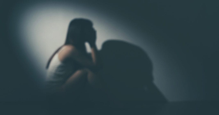woman sitting in a dark room