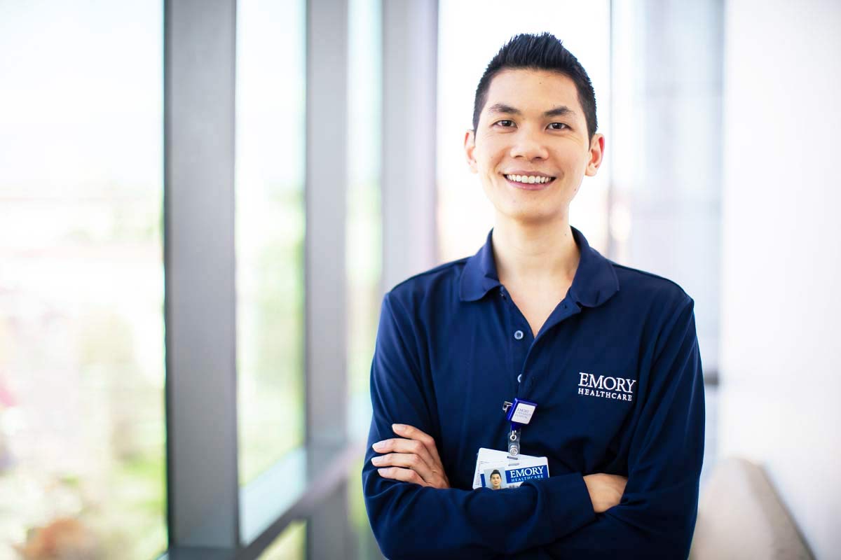 RN smiling in hospital hallway.