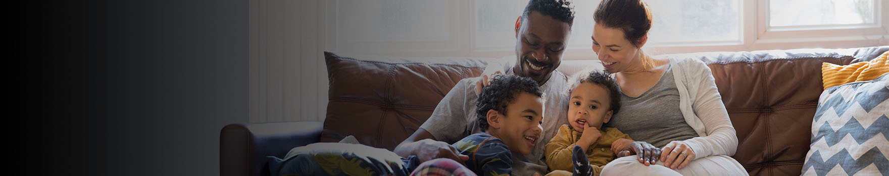 couple with two children on their living room sofa