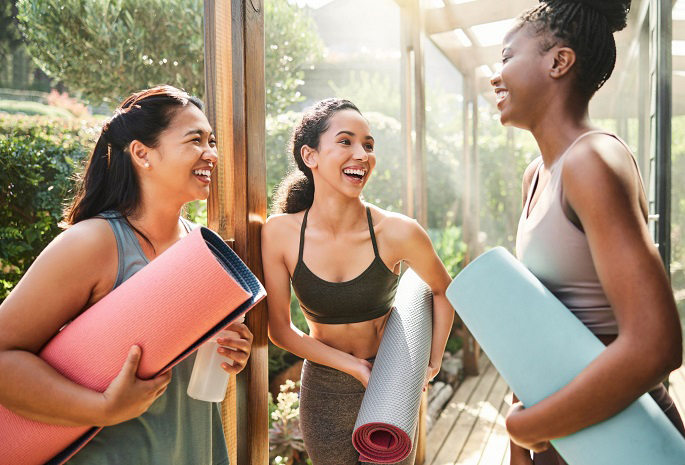women taking and laughing before exercise class