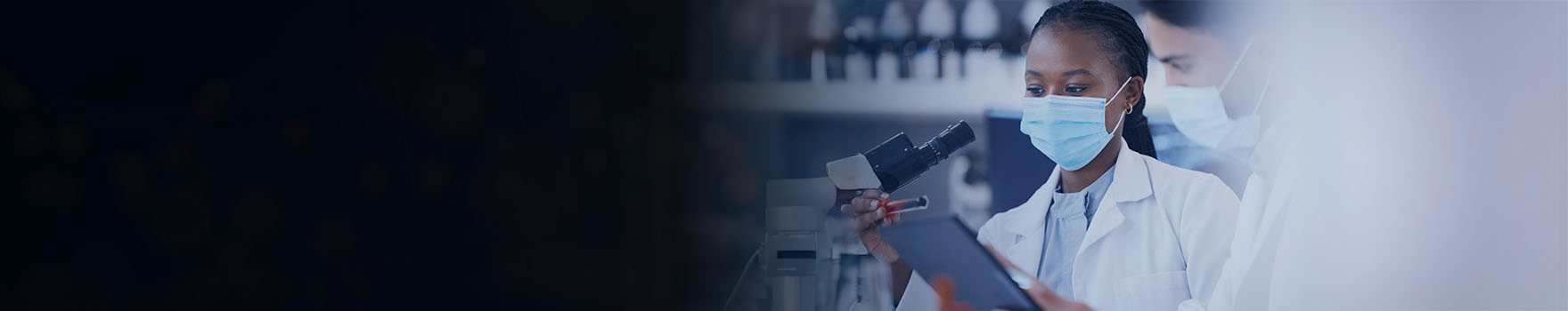 technicians in front of a microscope in a medical lab