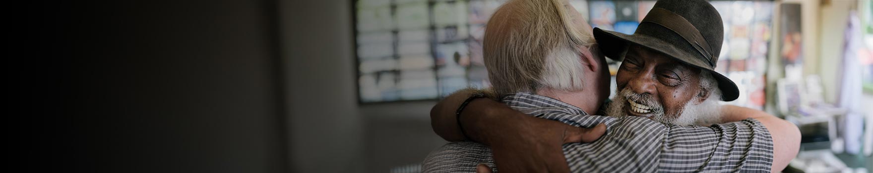 elderly men hugging