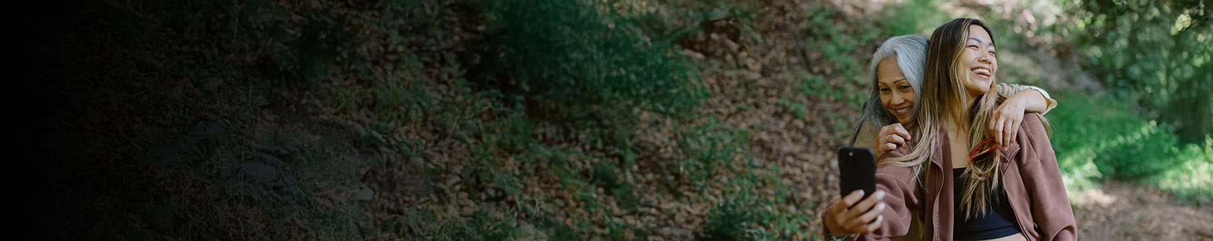young woman taking a selfie with her grandmother outdoors