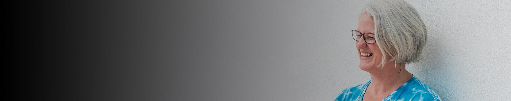 elderly woman wearing glasses, smiling