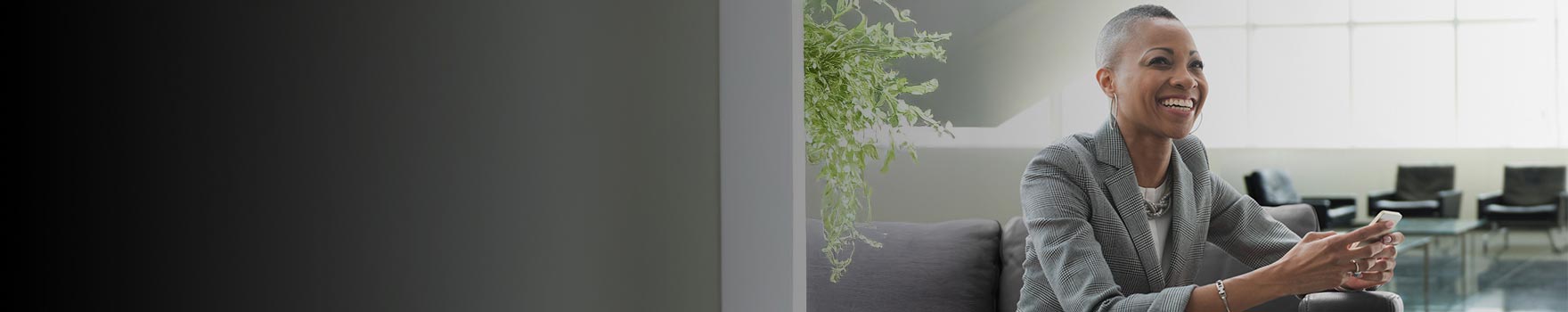 woman in business attire sitting and smiling