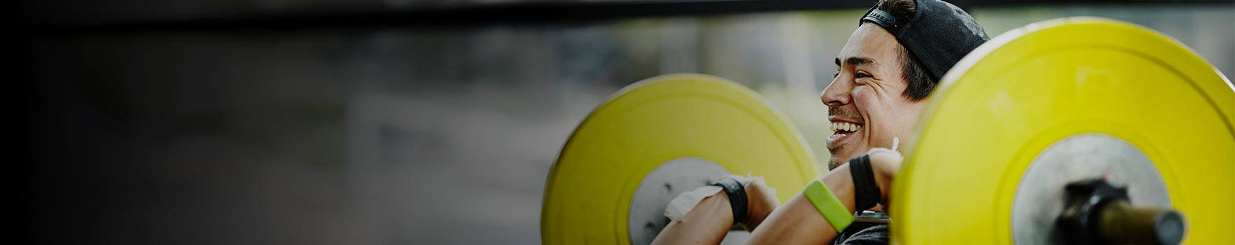 man lifting heavy weights and smiling