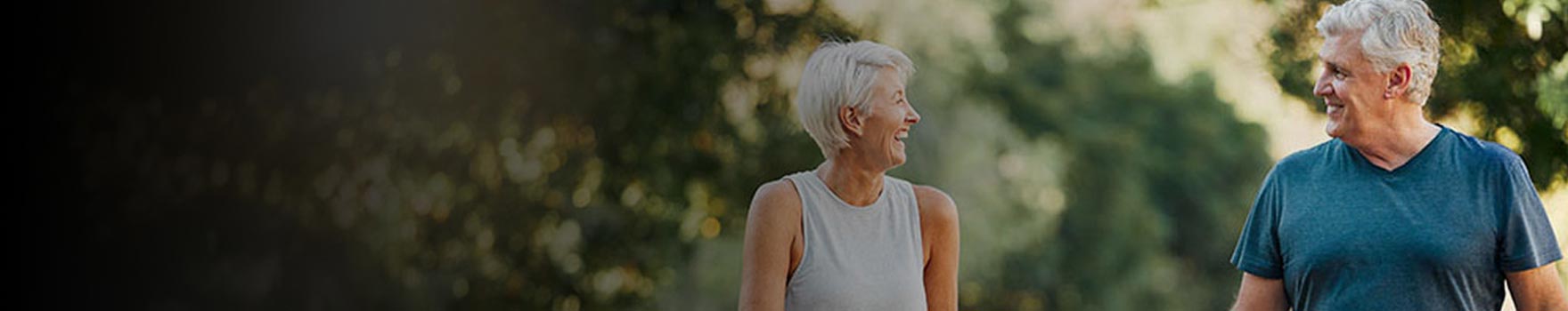 elderly man and woman out on a walk in the woods