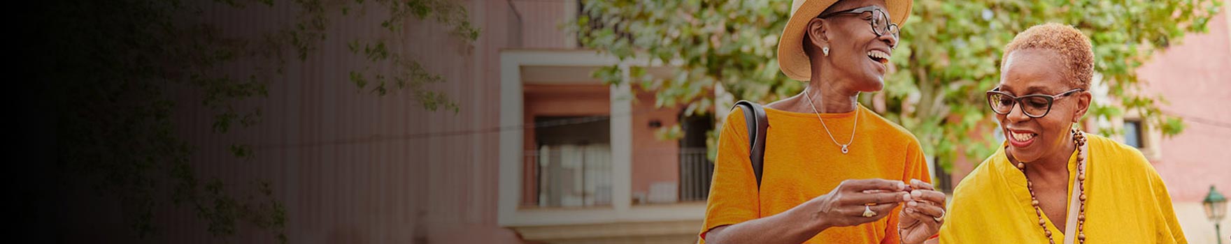 two women talking and laughing while walking outside
