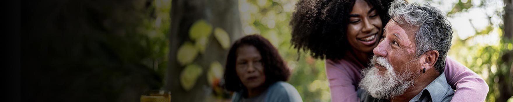 little girl hugging elderly man at a picnic