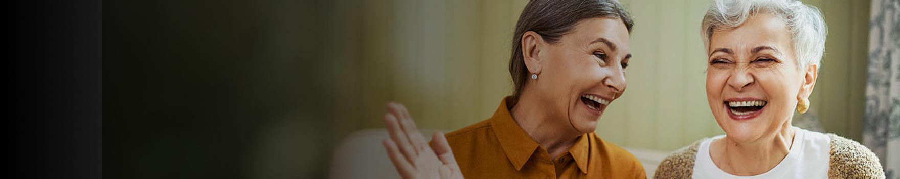 two women laughing and talking indoors