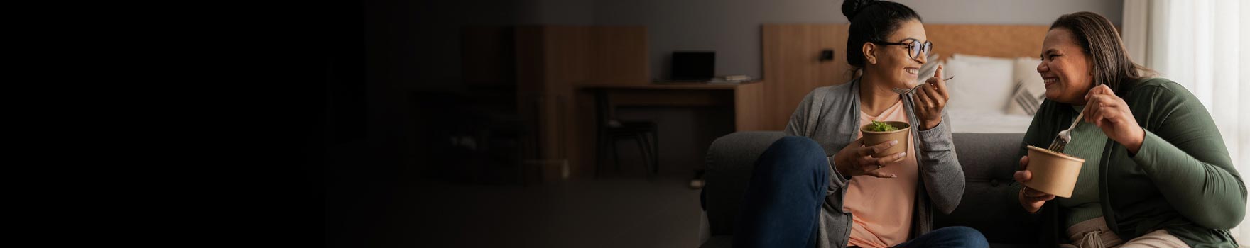 Women sitting together at home while eating a snack