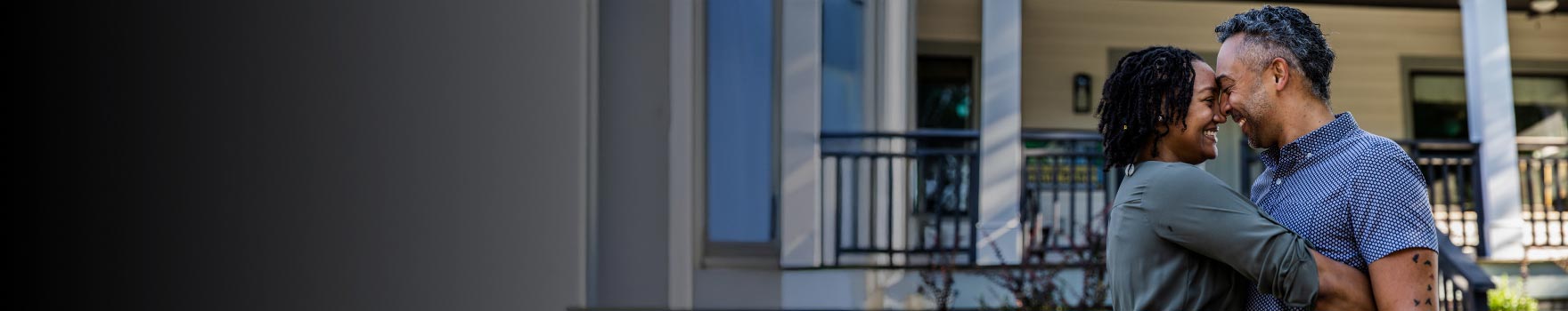 A black couple hugging each other in the front yard