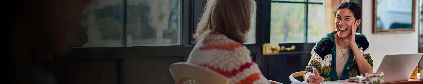 Two women talking to each other inside  
