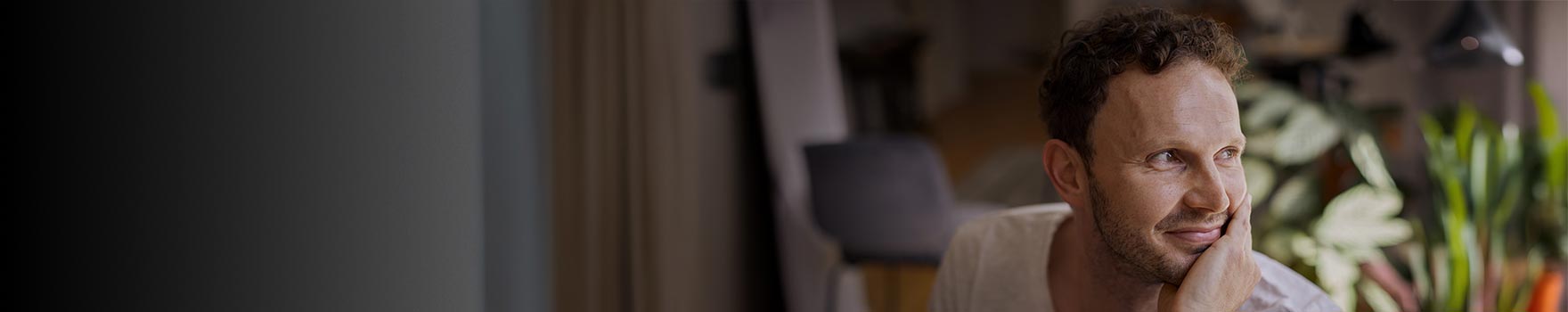 A man smilling while sitting on a yard