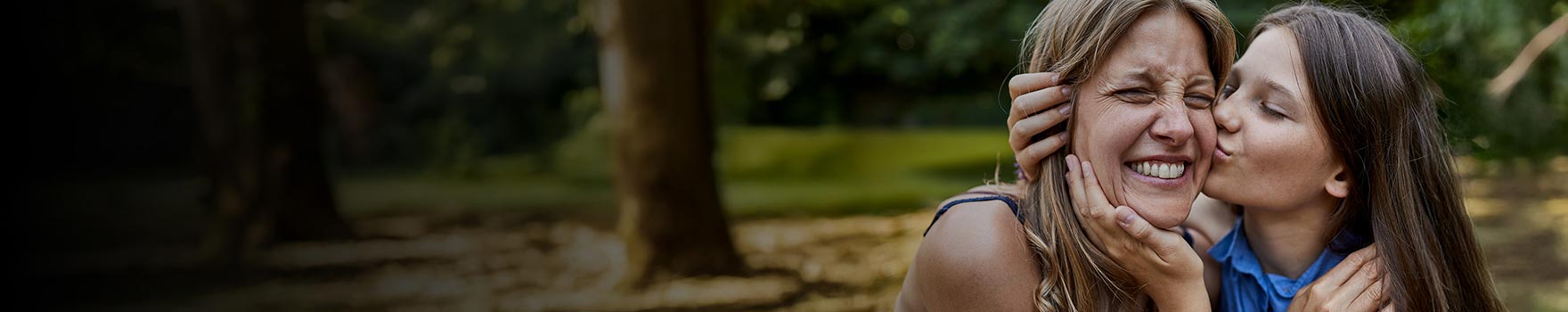 Two female siblings showing affection to each other outdoors