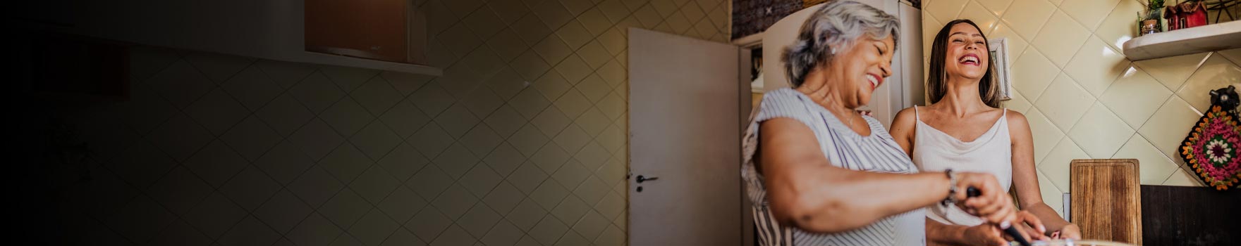 Two women in a kitchen cooking and having a good time