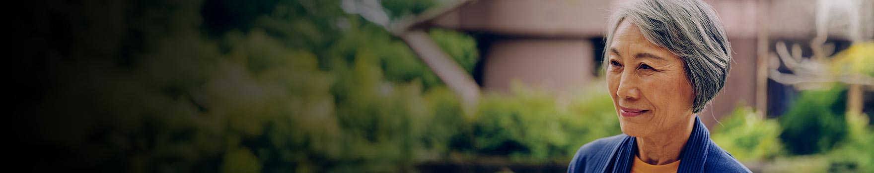 An older asian woman smiling outdoors