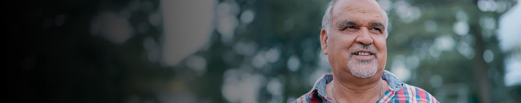 An older latino man walking outdoors 