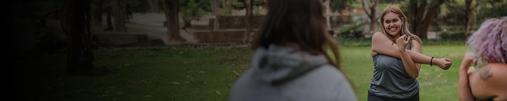 An outdoor group working out together and stretching