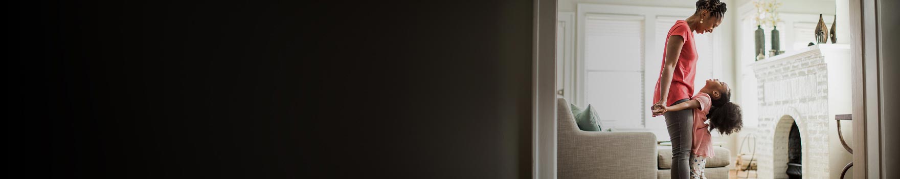 Mother and daughter playing and laughing in the living room