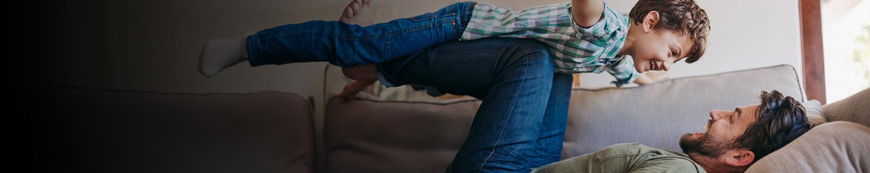 Father and son playing in the sofa