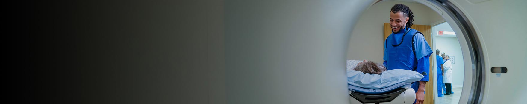 male technician speaking with female patient on MRI table