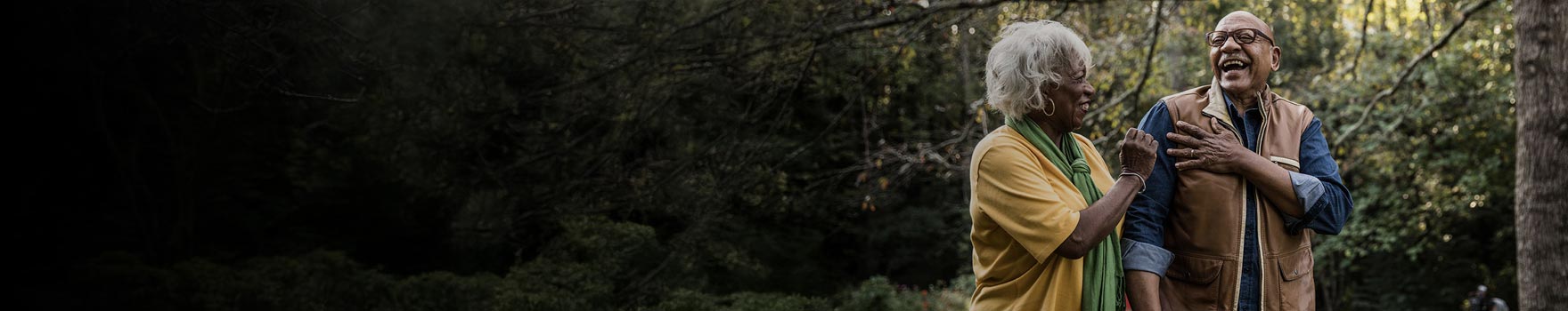 man and woman walking and laughing in the woods