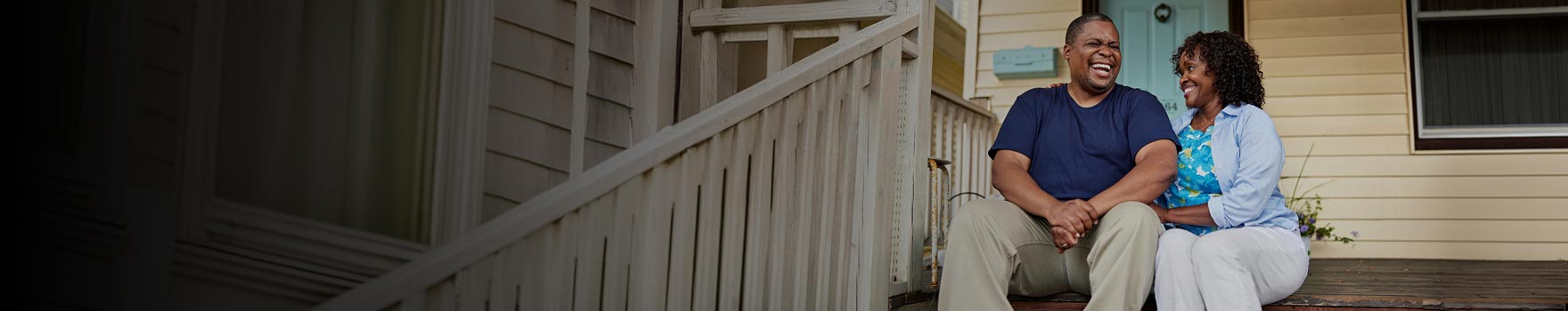 Two people sitting on a porch laughing