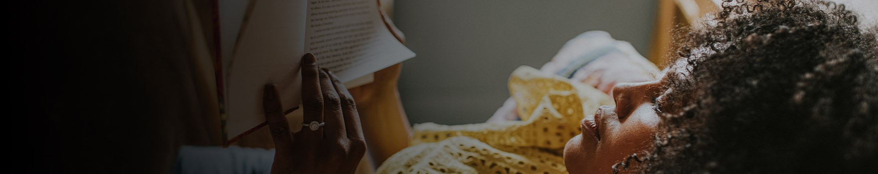 woman in bed reading a book