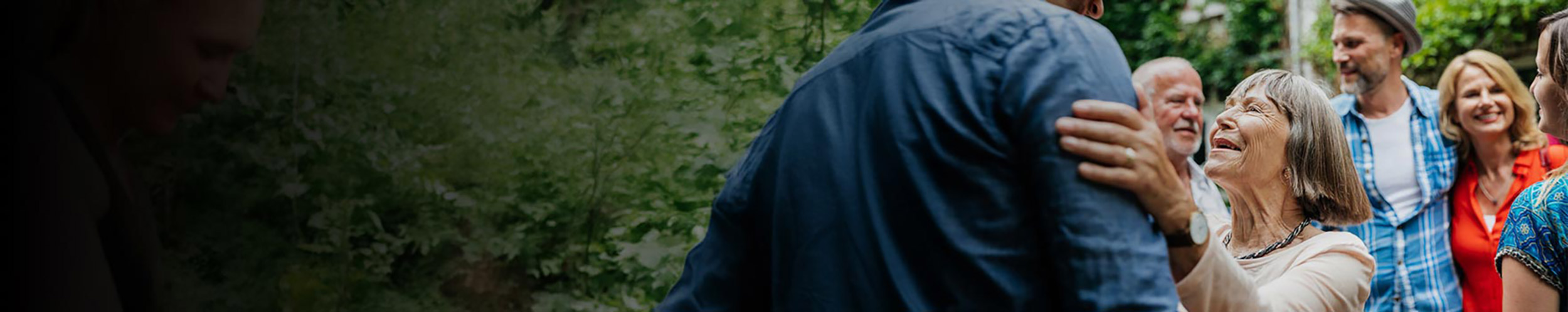 elderly woman with young man as a group looks on