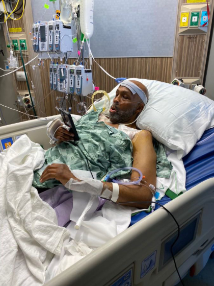 Sanders looking at his cell phone in a hospital bed