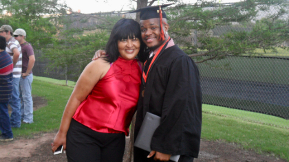 Roberts, in his graduation robe and cap, hugs his mom