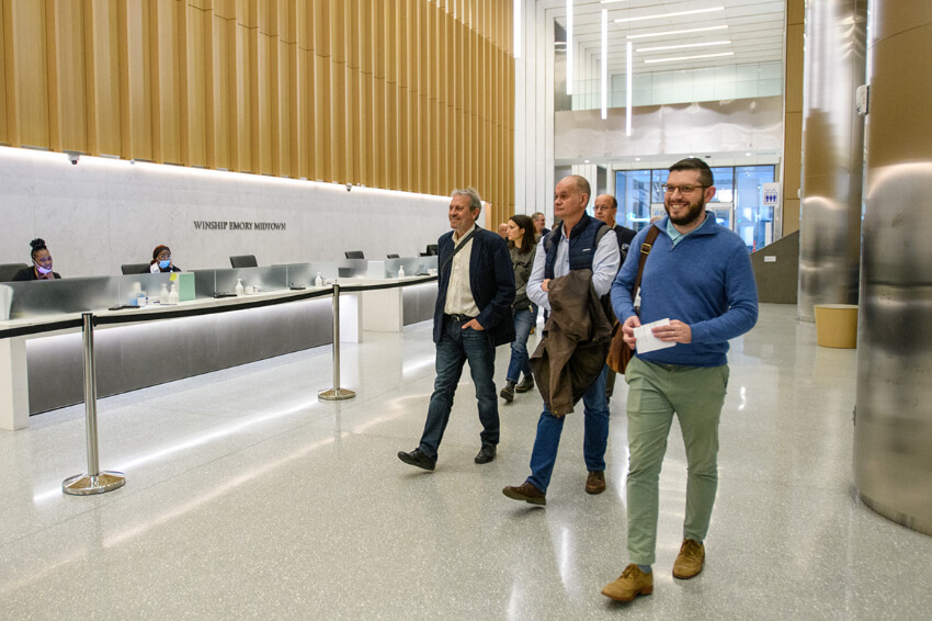 Members of delegation walking through lobby of Winship at Emory Midtown