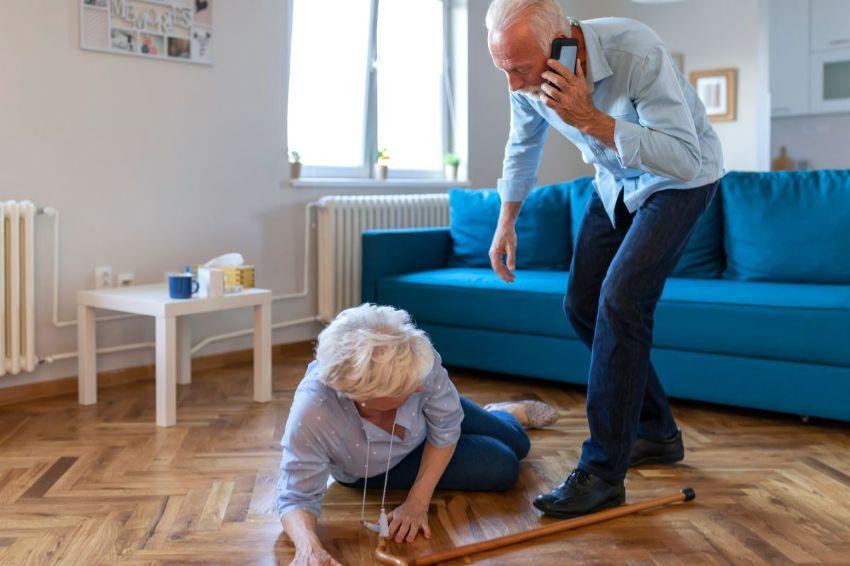 man on phone assisting woman who fell