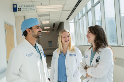 three surgical colleagues chatting in a hospital hallway